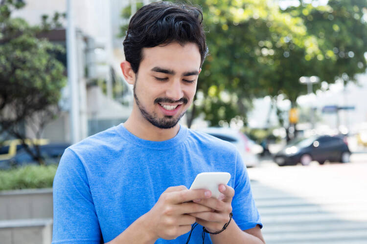 Mann lächelt und nutzt Smartphone