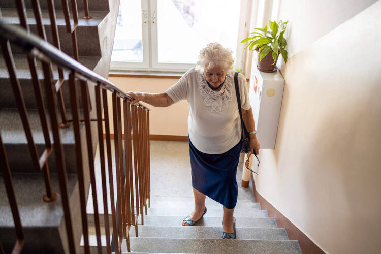 Ältere Frau versucht die Treppe hochzulaufen