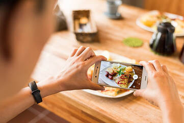 Mann macht Bild mit Smartphone von Essen