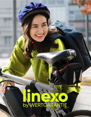 Eine Frau steht lächelnd neben ihrem Fahrrad